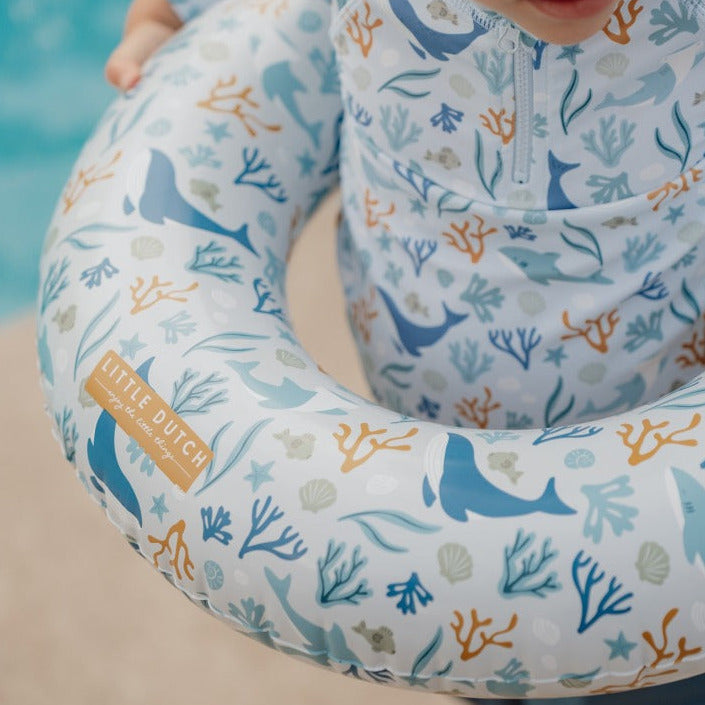 Kleinkind trägt einen hochwertigen Baby-Schwimmring im maritimen Ozean-Design am Pool. Der aufblasbare Schwimmring eignet sich für sicheren Wasserspaß, Urlaub und warme Sommertage.