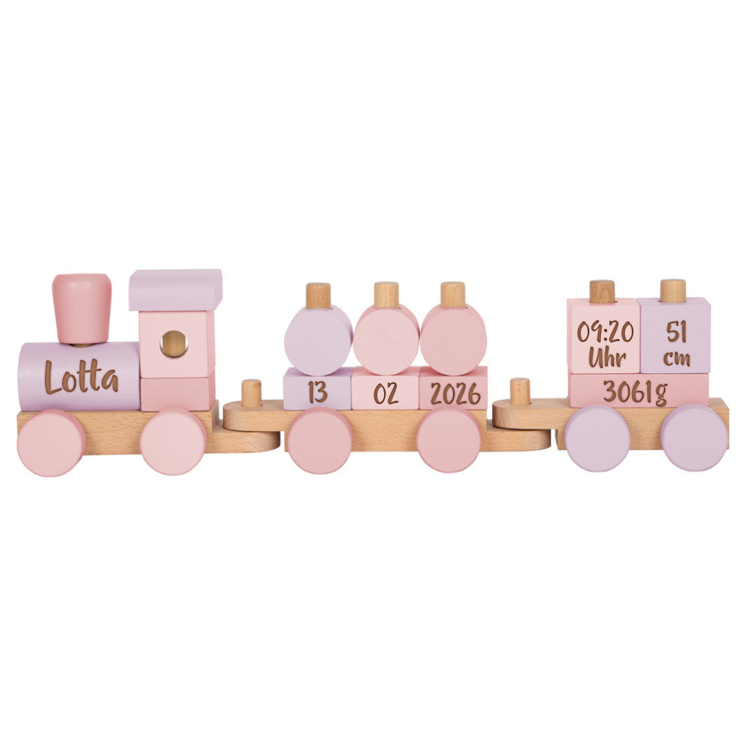 Kleines Kind spielt mit einem personalisierten Smallfoot Holzzug in Rosa mit Name und Geburtsdaten zur Geburt