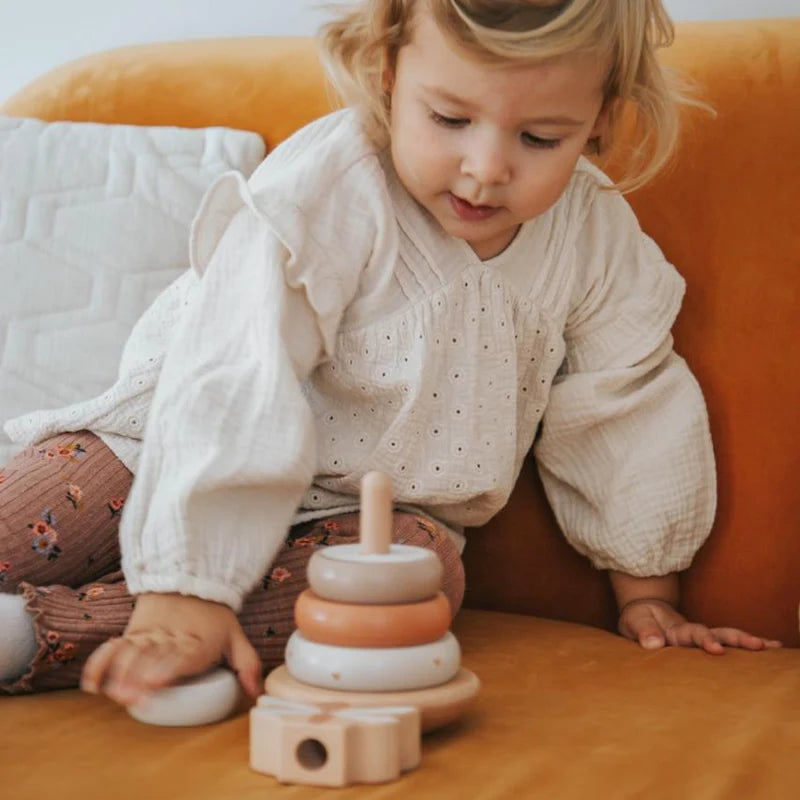 Kind spielt mit dem Label Label Balance-Stapelturm Nougat