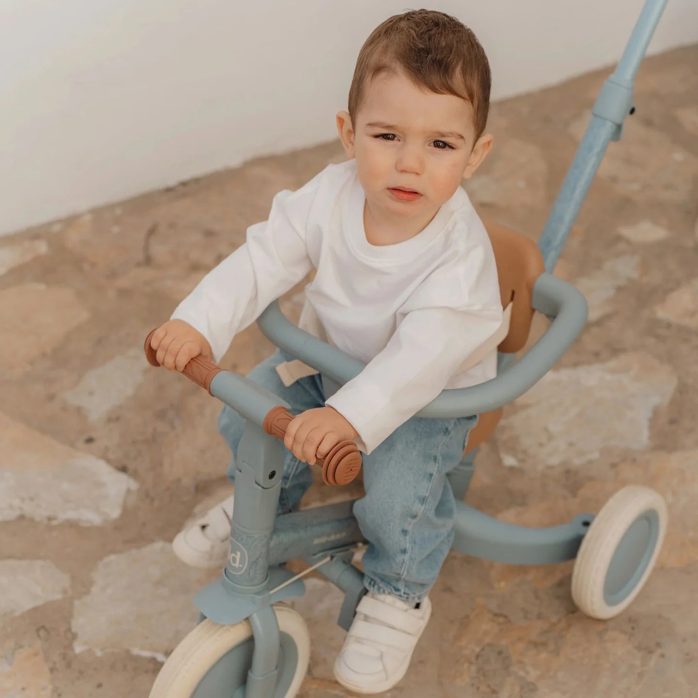 Kind fährt das Little Dutch Tricycle 4-in-1 in Blau mit Schubstange. Das wandelbare Dreirad und Laufrad fördert Balance, Koordination und Motorik für Kinder ab 1 Jahr.