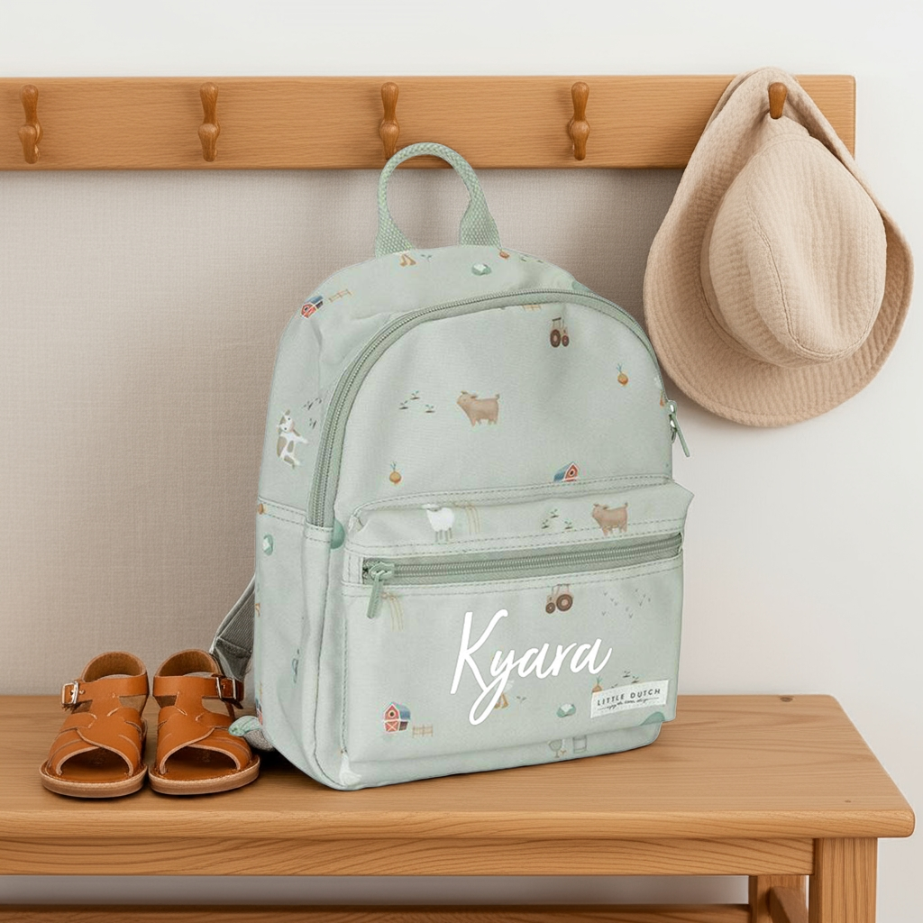 Personalisierter Kinderrucksack Little Farm mit Namen Kyara für Kindergarten und Kita auf einer Holzbank